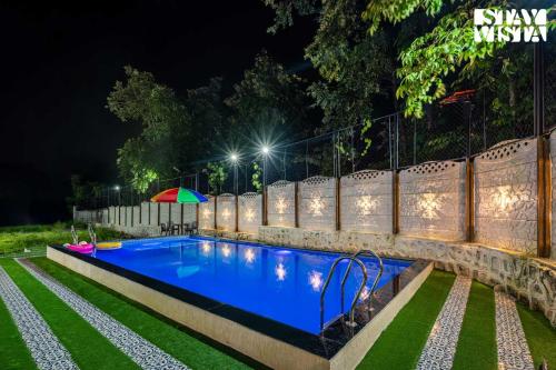 Una piscina en un patio por la noche. en StayVista at Casa Tino with Bonfire, Lawn, en Karjat