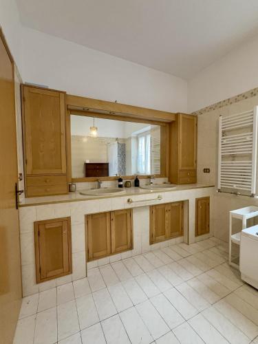 a large kitchen with wooden cabinets and a window at La casa tra gli ulivi di Fonte Nuova in Fonte Nuova