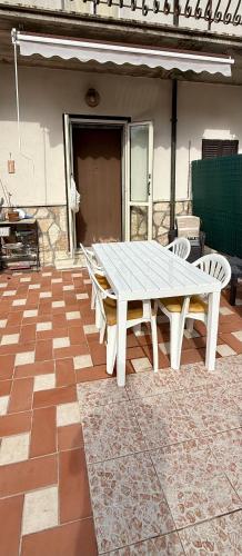 a white picnic table and chairs on a patio at La casa tra gli ulivi di Fonte Nuova in Fonte Nuova