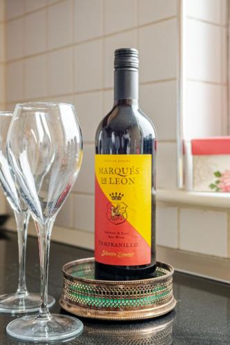 a bottle of wine sitting next to a wine glass at Amazing River view 2 bedroom apartment, sleeps 6 , balcony and parking in London