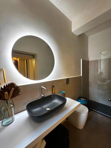 a bathroom with a black sink and a mirror at Ginevra Boutique Rooms - Palazzo Leosini - Residenze D'Epoca in LʼAquila