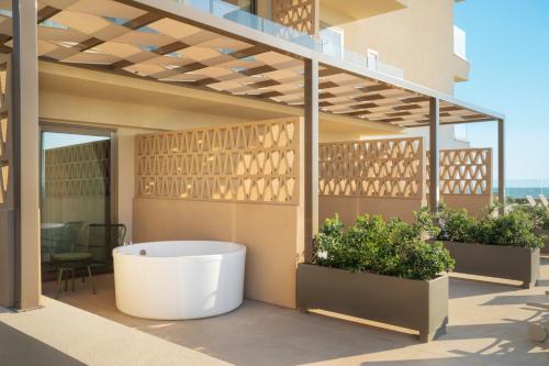 a balcony with a bath tub on a building at Iberostar Selection Es Trenc -New Opening- in Colonia Sant Jordi