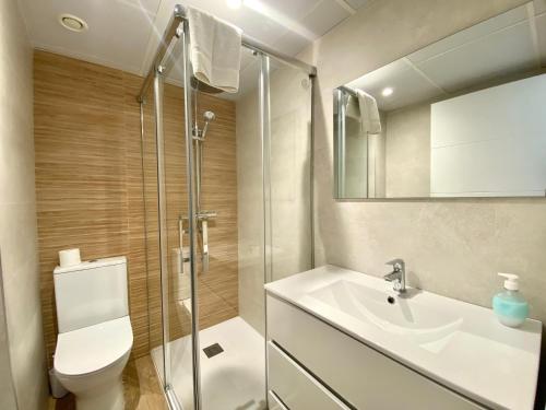 Un baño con inodoro, lavabo y ducha. en Novamar Apartamentos, en Fuengirola