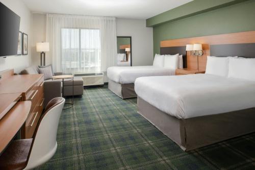 a hotel room with two beds and a television at TownePlace Suites by Marriott Billings in Billings