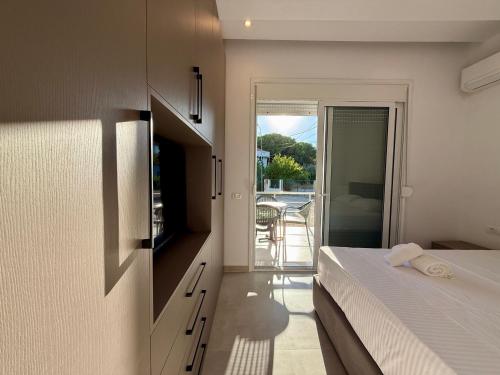 a bedroom with a bed and a view of a balcony at Vlora forest Apartments in Vlorë