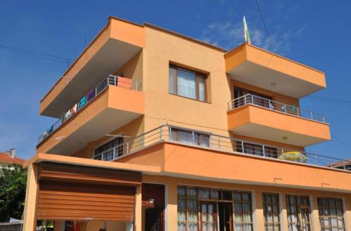 an orange building with balconies on top of it at Rooms Ivanka Ground Floor in Obzor
