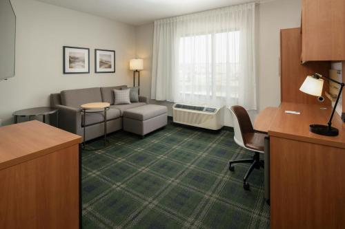 a living room with a couch and a desk in a hotel room at TownePlace Suites by Marriott Billings in Billings