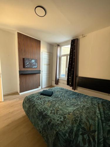 a bedroom with a bed and a large window at La Symphonie 1 charme au coeur de la cité Vauban in Gravelines