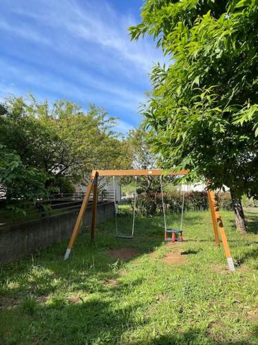 a swing set in a yard next to a tree at Wanderlust per chi ama la natura in Laino Castello