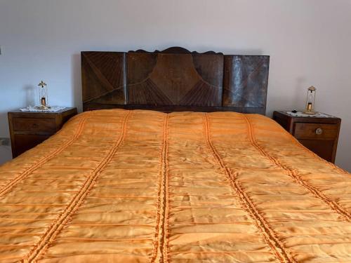 a large orange bed with two night stands next to it at Wanderlust per chi ama la natura in Laino Castello