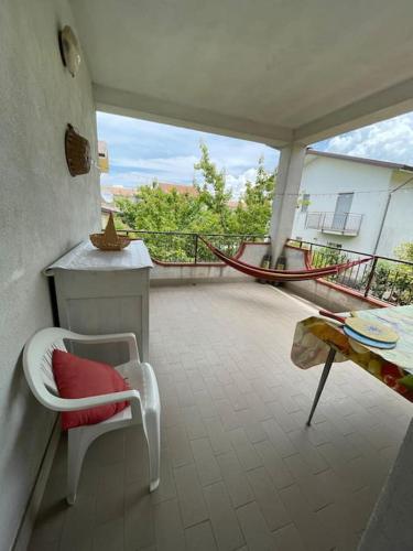a balcony with a chair and a table and a hammock at Wanderlust per chi ama la natura in Laino Castello