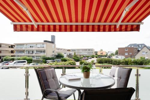 a table and chairs on a balcony with a view at Blankwasserweg 57 Wohnung 5 in Grömitz