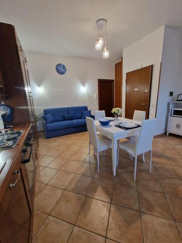 Una cocina y una sala de estar con una mesa y sillas blancas. en La Casa di Taty, en Campagnano di Roma