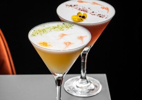 two cocktails sitting on top of a table at Montebelo Vista Alegre Lisboa Chiado Hotel in Lisbon