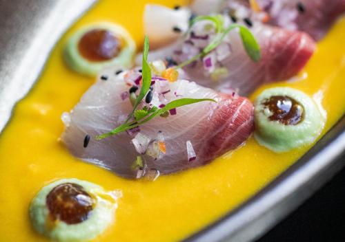 a plate of food with sushi on a yellow plate at Montebelo Vista Alegre Lisboa Chiado Hotel in Lisbon