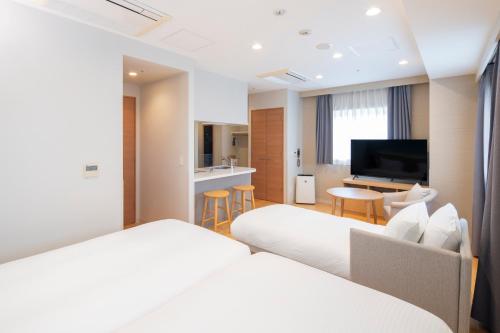 a hotel room with two beds and a flat screen tv at La'gent Stay Sapporo Odori Hokkaido in Sapporo