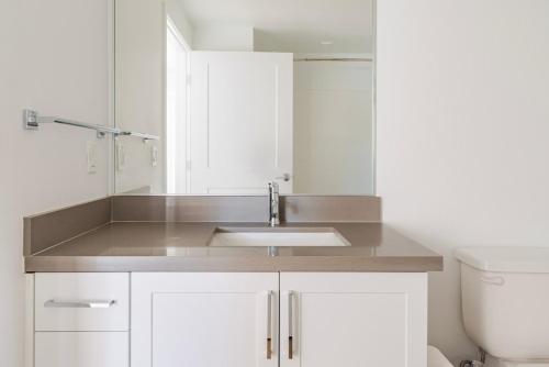 ein weißes Badezimmer mit Waschbecken und Toilette in der Unterkunft Blueground Pleasant Hill balcony nr Park SFO-1906 in San Francisco