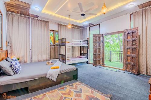 a bedroom with a bed and a large window at Ekayana Resorts and Agri Tourism, Mulshi in Pune