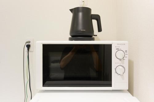 a coffee pot sitting on top of a microwave at Zenith Garden TOGOSHI in Tokyo
