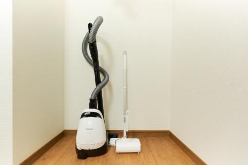 a vacuum cleaner in a corner of a room at Zenith Garden TOGOSHI in Tokyo