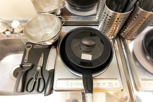 a kitchen sink with a frying pan and utensils at Zenith Garden TOGOSHI in Tokyo