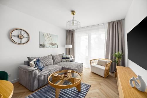 a living room with a couch and a table at Rezydencja Merwede Aparthotel - My Rest in Gdańsk
