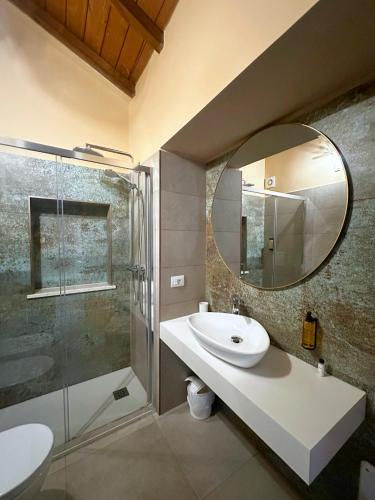 a bathroom with a sink and a shower and a mirror at Ginevra Boutique Rooms - Palazzo Leosini - Residenze D'Epoca in LʼAquila