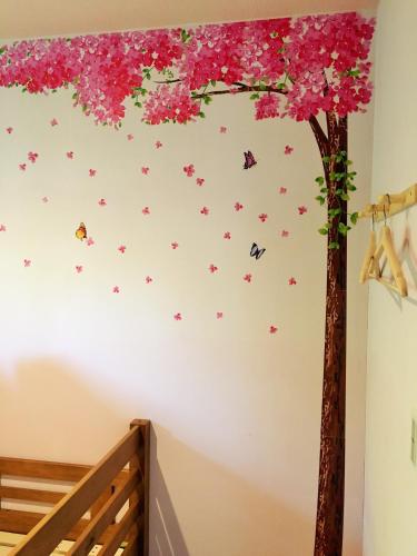 a tree with flowers and butterflies on a wall at ホステル富士山 結 in Fujiyoshida