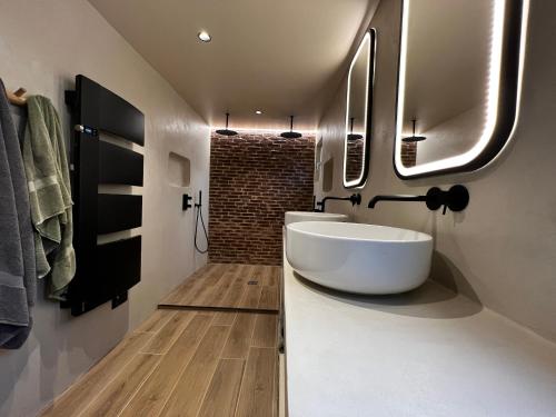 une salle de bain avec un lavabo blanc et un miroir dans l'établissement Chaleureuse ferme restaurée au calme avec piscine, à Fiquefleur-Équainville