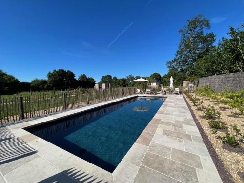 une piscine dans une cour clôturée dans l'établissement Chaleureuse ferme restaurée au calme avec piscine, à Fiquefleur-Équainville