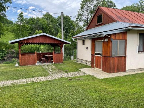 a house with a gazebo in the yard at Chata Babulik in Veľká Lesná