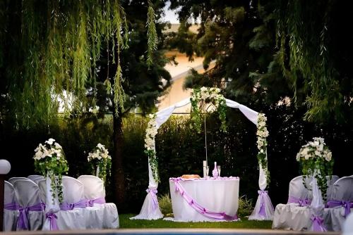 a table with white chairs and a table with flowers at Hotel Racic Self-Check In in Voyvodinovo