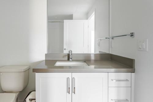 a white bathroom with a sink and a toilet at Blueground Pleasant Hill view nr Mount Diablo SFO-1907 in San Francisco