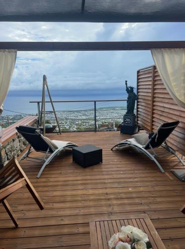 a deck with chairs and the statue of liberty at L'étoile du Pic in Sainte-Clotilde