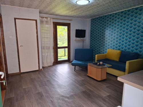 a living room with two blue chairs and a table at Bunaglows Panoramic Beach Village in Balchik