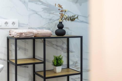 a black shelf with a plant on it in a bathroom at Estudio barrio Patraix - cerca del Centro in Valencia