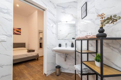 a bathroom with white marble walls and a sink at Estudio barrio Patraix - cerca del Centro in Valencia