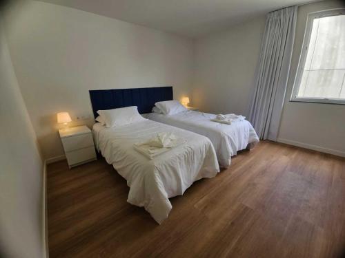 a bedroom with two beds and a window at Apartamento Sonho Terra in Ponta Delgada