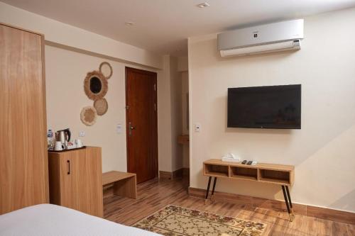 a bedroom with a bed and a television on the wall at Golden pyramids group in Nazlet el-Sîsi