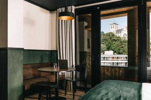 a room with a bed and a table with a laptop at Getaway Studios Liège in Liège