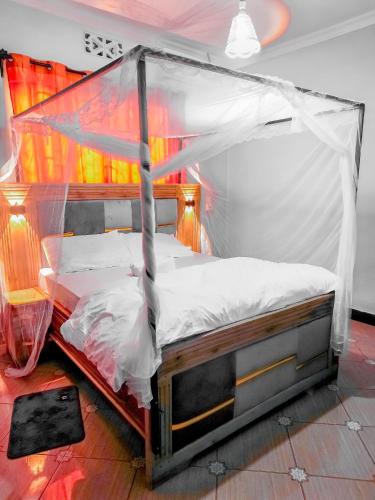 a bed with a canopy in a room at karibu la kossa in Tuvaila