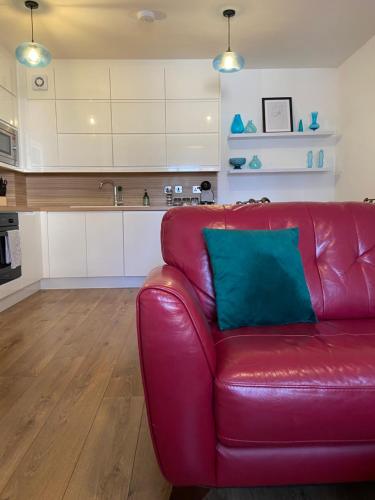a red leather couch in a living room with a kitchen at Marina Suite 1 Bed Duplex ER104 in Hull