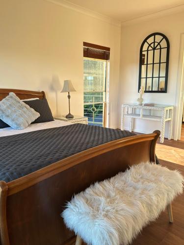 a bedroom with a large bed with a furry rug at River Rock Retreat in Maroochy River