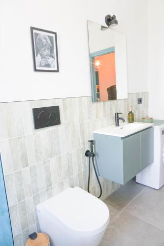 a bathroom with a white toilet and a sink at Il Biru in Montelupo Albese