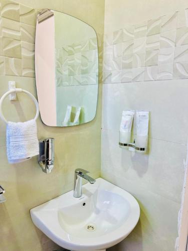 a bathroom with a sink and a mirror at Mengeni Homes in Dodoma