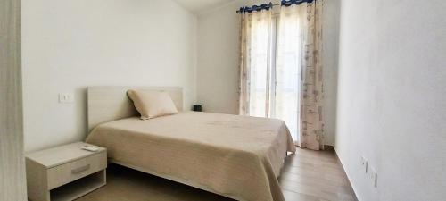 a small bedroom with a bed and a window at Affittimoderni Trinita D Agultu - Casa di Andreas in Cascabraga