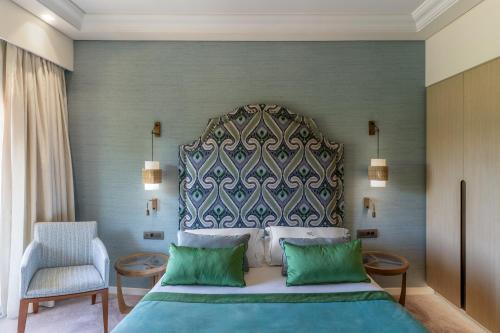 a bedroom with a large bed and a chair at Rodos Park in Rhodes Town