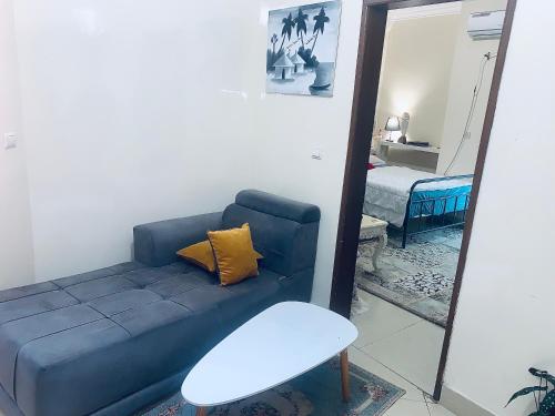 a living room with a blue couch and a mirror at Lola in Dakar