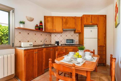 a kitchen with a wooden table with chairs and a sink at Villa Caballero by Villa Plus in Punta Prima