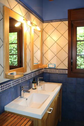 a bathroom with two sinks and two mirrors at Casa La Escollera in Cangas de Onís